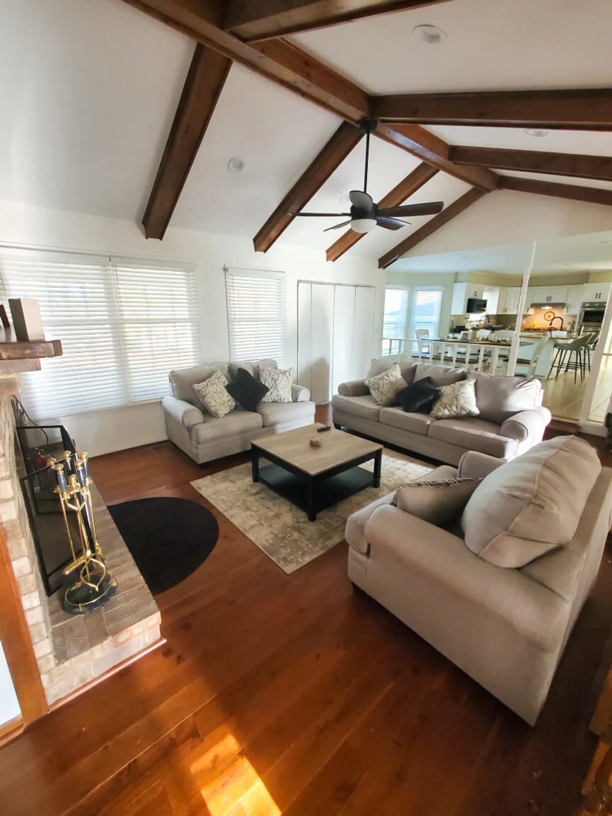 A comfortable den space with cozy sofas, a coffee table, an inviting fireplace, and exposed ceiling beams. The ambience is warm and intimate, ideal for games, laughter, or curling up with a book or cup of tea.