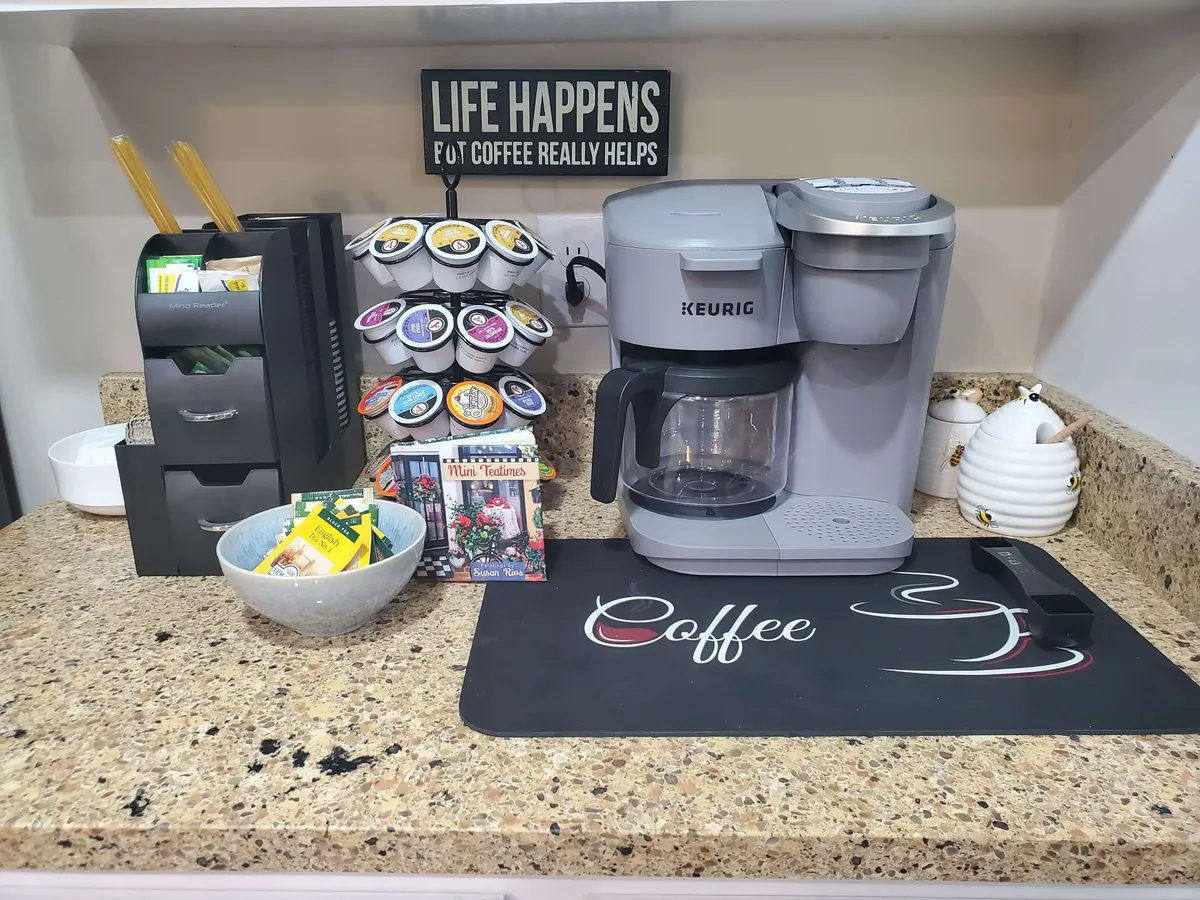 A welcoming coffee and drink station featuring a Keurig coffee maker, a carousel of coffee pods, and cheerful signage. This inviting corner beckons for morning rituals or late-night chats over a warm beverage.
